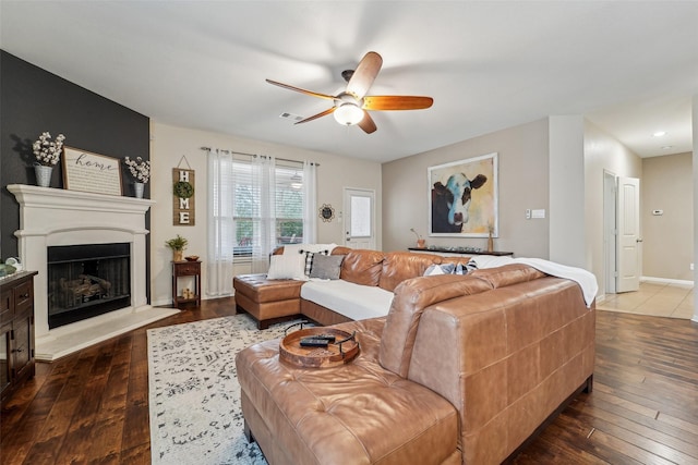 living room with ceiling fan, wood-type flooring, and a fireplace