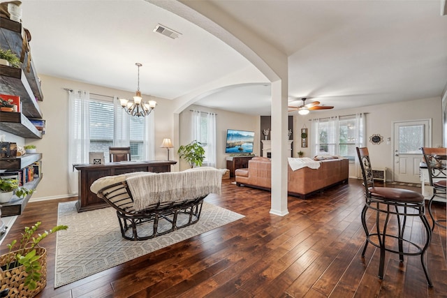 interior space with ceiling fan with notable chandelier and dark hardwood / wood-style floors