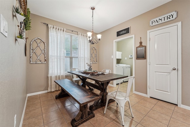 tiled dining space with a chandelier and washer and clothes dryer