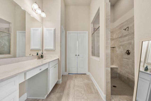 bathroom featuring tiled shower and vanity