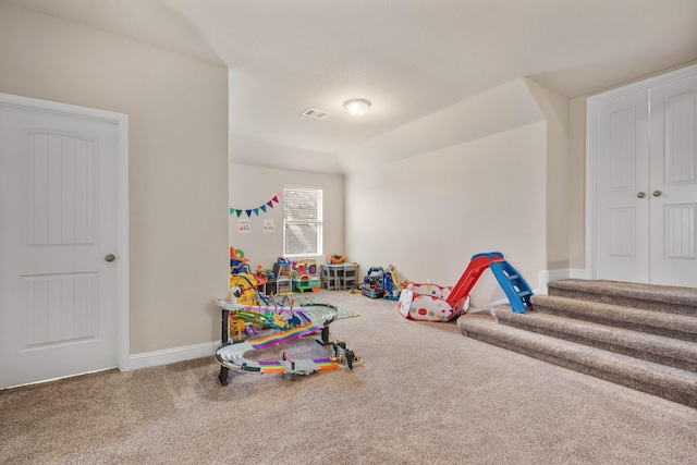 playroom featuring vaulted ceiling and carpet flooring