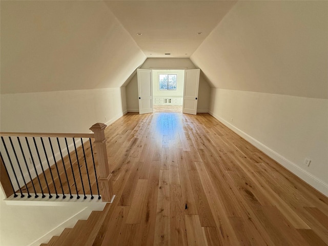 additional living space featuring lofted ceiling and light hardwood / wood-style floors