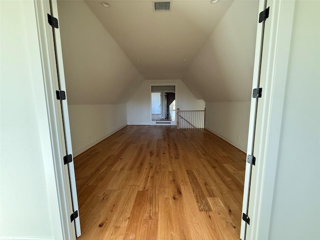 additional living space with vaulted ceiling and light hardwood / wood-style floors