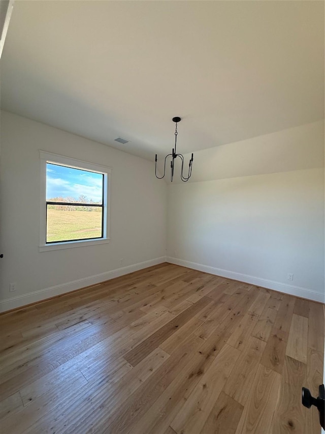 unfurnished dining area featuring light wood-type flooring and an inviting chandelier