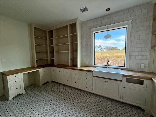 unfurnished office featuring built in desk and sink