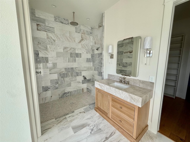 bathroom with vanity and tiled shower