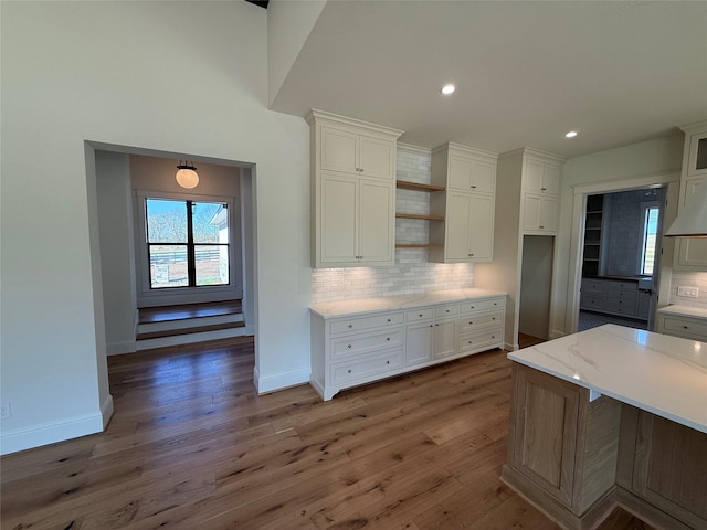 kitchen with dark wood-type flooring, white cabinets, and decorative backsplash