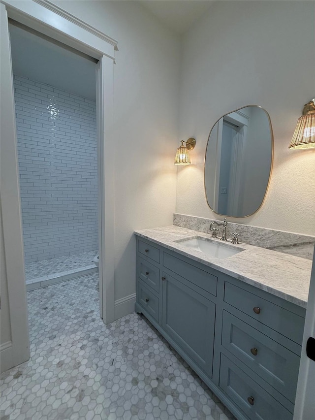 bathroom featuring vanity and tiled shower