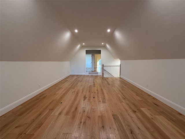 bonus room with lofted ceiling and light wood-type flooring