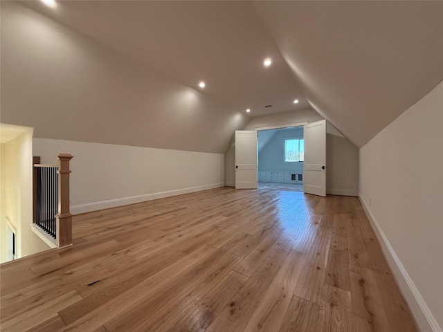 additional living space with lofted ceiling and light wood-type flooring