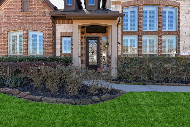 entrance to property featuring a lawn