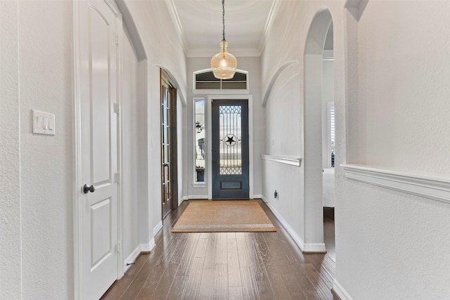 foyer entrance with dark hardwood / wood-style flooring and ornamental molding