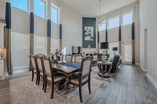 dining room featuring ceiling fan, a healthy amount of sunlight, and a high ceiling