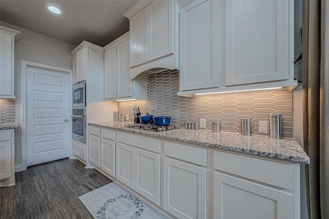 kitchen featuring white cabinets, appliances with stainless steel finishes, and tasteful backsplash