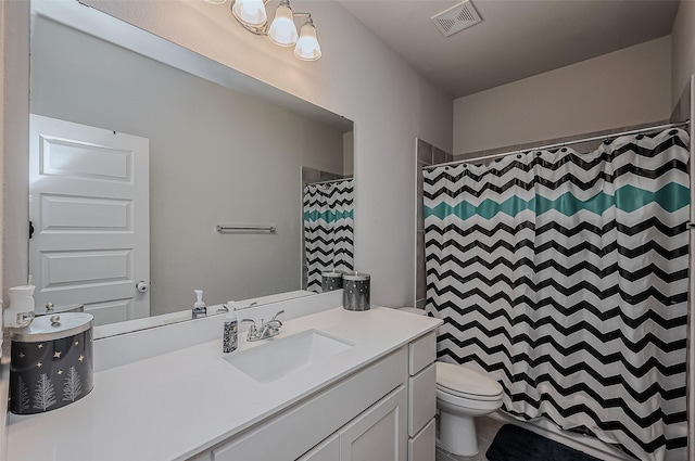 bathroom featuring toilet, vanity, and curtained shower