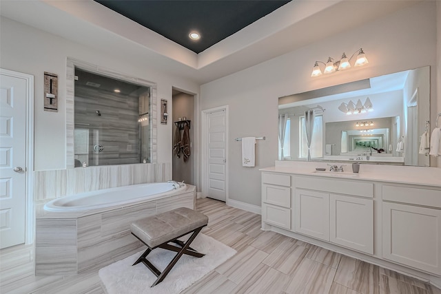 bathroom featuring vanity and independent shower and bath