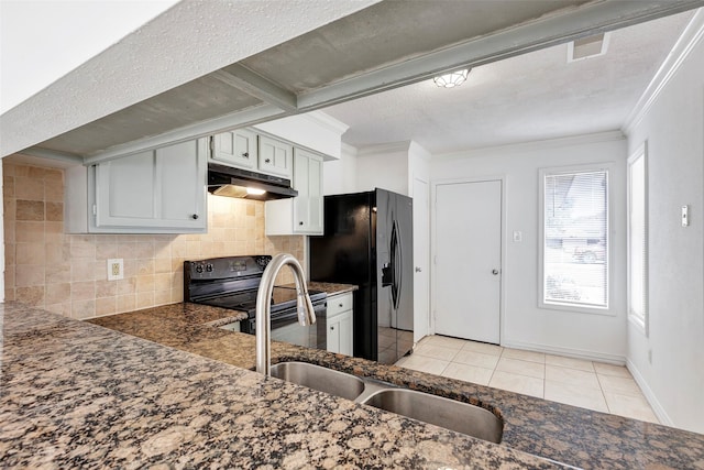 kitchen with a textured ceiling, black appliances, tasteful backsplash, light tile patterned floors, and crown molding