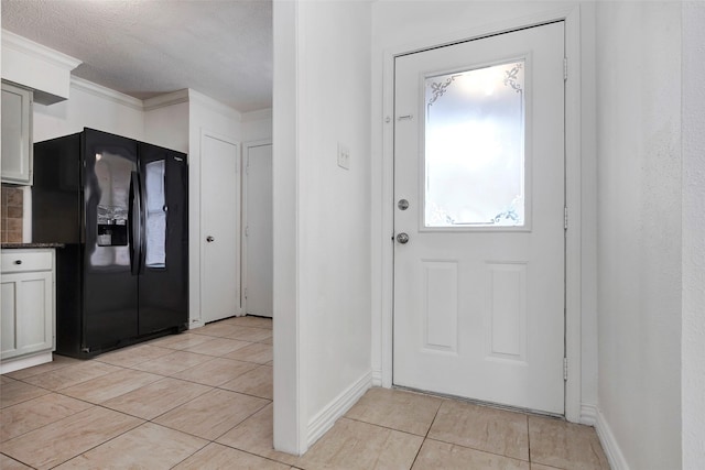 doorway with light tile patterned flooring and a textured ceiling