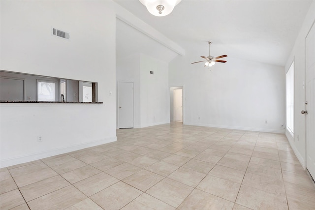 spare room featuring ceiling fan, a healthy amount of sunlight, beamed ceiling, and light tile patterned flooring