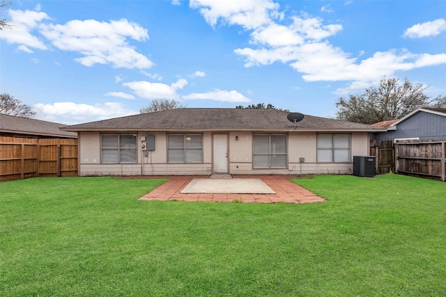 rear view of property featuring a lawn, cooling unit, and a patio area