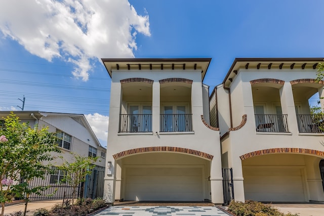 view of front of property featuring a balcony and a garage