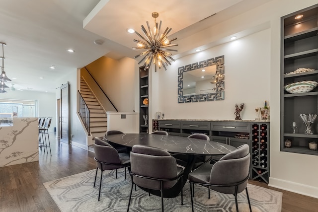 dining room featuring built in shelves, dark hardwood / wood-style floors, and a chandelier