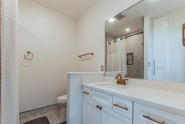 bathroom featuring curtained shower, toilet, and vanity