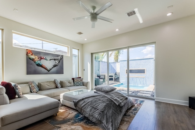 living room featuring ceiling fan and dark hardwood / wood-style floors