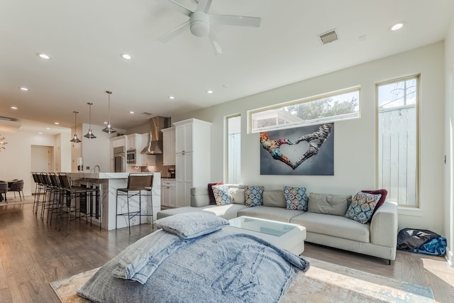 living room featuring wood-type flooring and ceiling fan