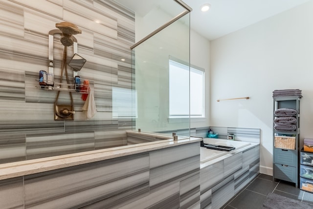 bathroom with tile patterned flooring and a relaxing tiled tub