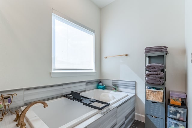 bathroom with tile patterned floors and tiled bath