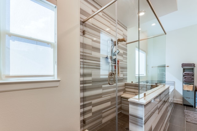 bathroom with an enclosed shower and tile patterned floors