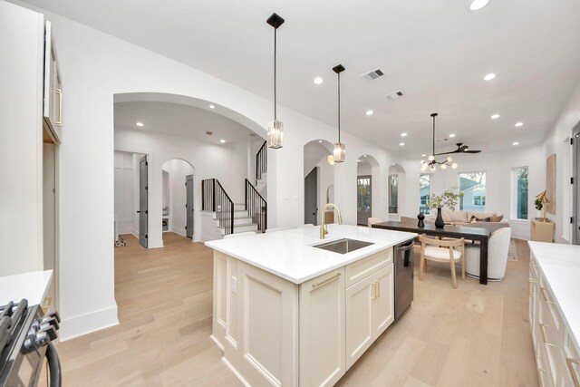 kitchen featuring pendant lighting, sink, ceiling fan, appliances with stainless steel finishes, and a kitchen island with sink