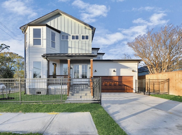 view of front of home featuring a porch, a garage, and a front yard