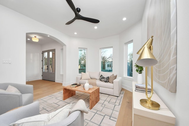 living room featuring ceiling fan, plenty of natural light, and light hardwood / wood-style floors