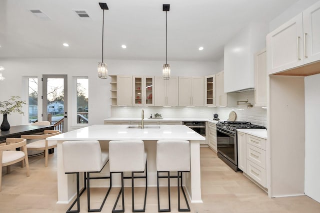 kitchen featuring white cabinetry, sink, an island with sink, and appliances with stainless steel finishes