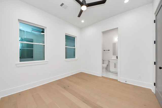 unfurnished bedroom featuring ensuite bathroom, sink, ceiling fan, and light hardwood / wood-style floors