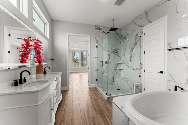 bathroom with ceiling fan, vanity, and shower with separate bathtub