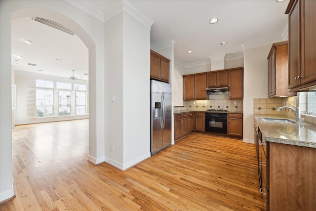 kitchen featuring stainless steel appliances, decorative backsplash, sink, ornamental molding, and light stone counters