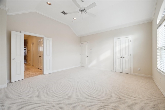 unfurnished bedroom featuring light carpet, ceiling fan, ornamental molding, and vaulted ceiling