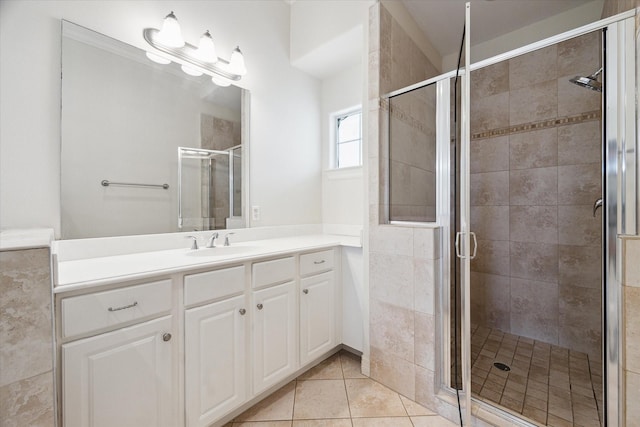 bathroom with tile patterned flooring, a shower with door, and vanity