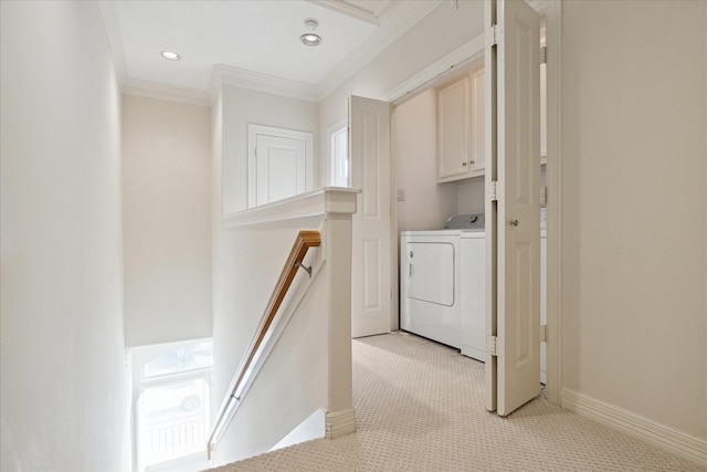 laundry room with washing machine and dryer, cabinets, ornamental molding, and light carpet