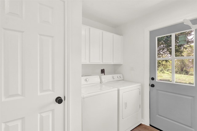 washroom with wood-type flooring, cabinets, a healthy amount of sunlight, and washing machine and clothes dryer