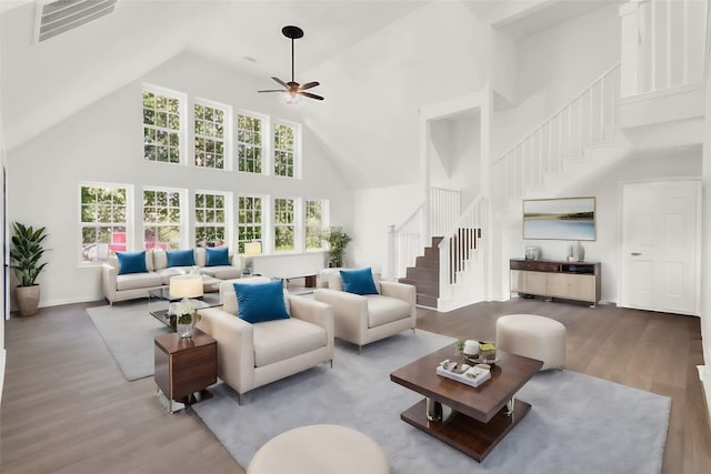 living room with ceiling fan, wood-type flooring, and a high ceiling