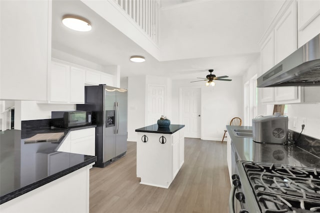 kitchen with white cabinets, appliances with stainless steel finishes, a kitchen island, ventilation hood, and light hardwood / wood-style flooring