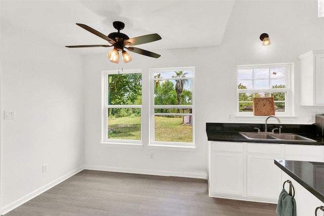 kitchen featuring ceiling fan, sink, white cabinetry, and light hardwood / wood-style floors