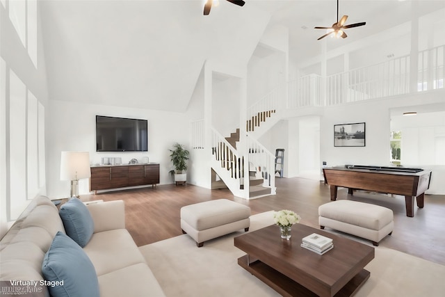 living room with ceiling fan, wood-type flooring, a high ceiling, and billiards