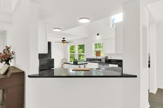 kitchen with dark wood-type flooring, white cabinets, kitchen peninsula, and dishwasher