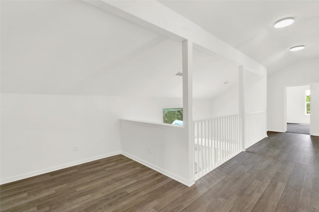 corridor featuring dark wood-type flooring and lofted ceiling