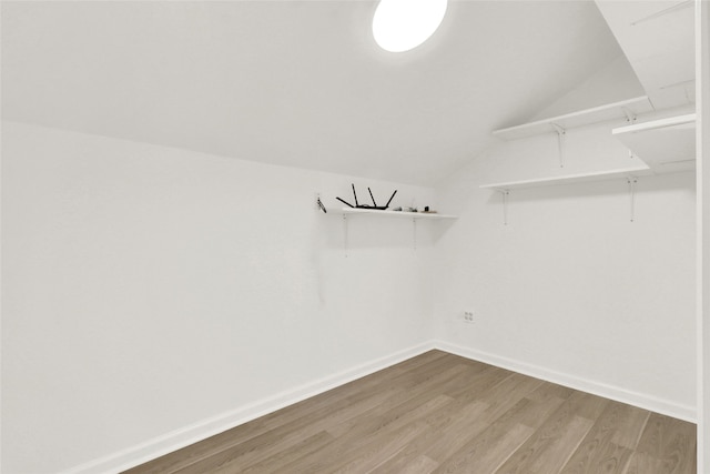 walk in closet with wood-type flooring and lofted ceiling